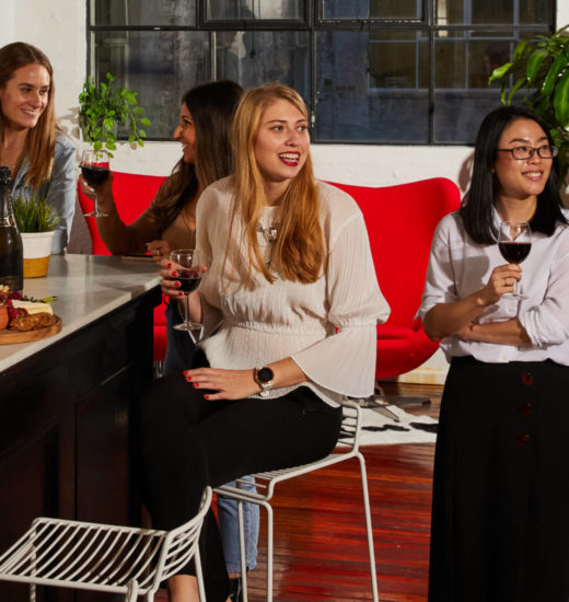 Four people holding drinks in a bar