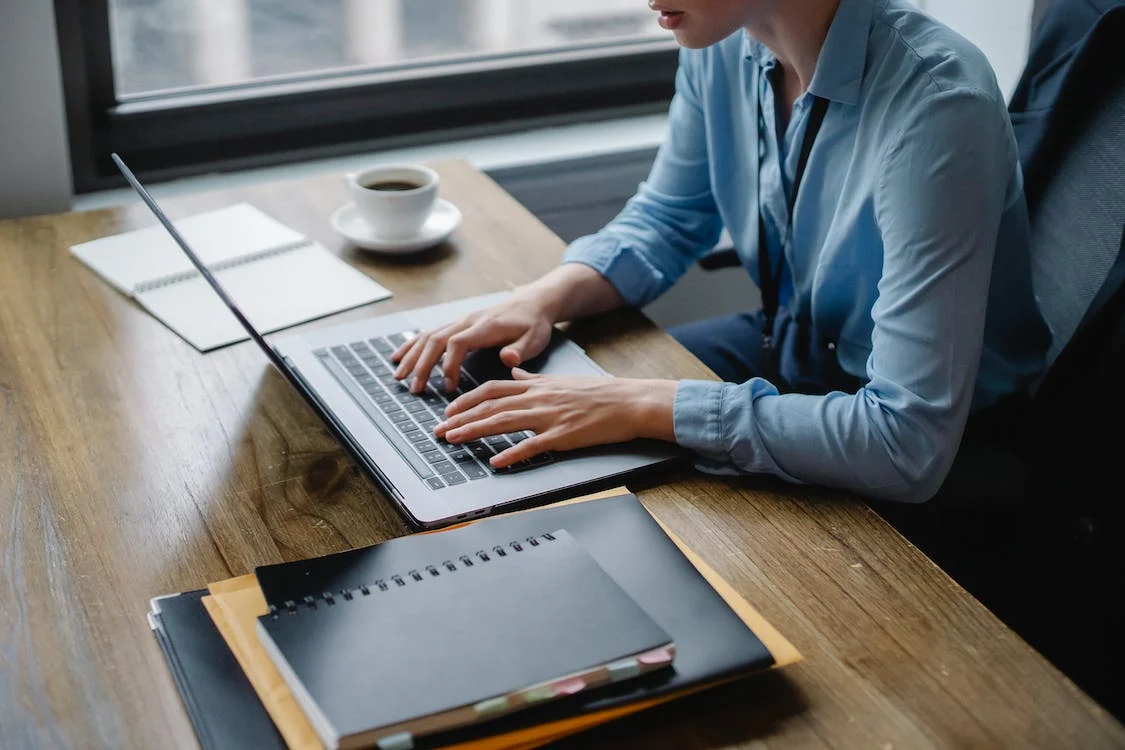 woman typing on her laptop at her desk
