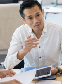 guy holding a tablet while chatting with colleagues