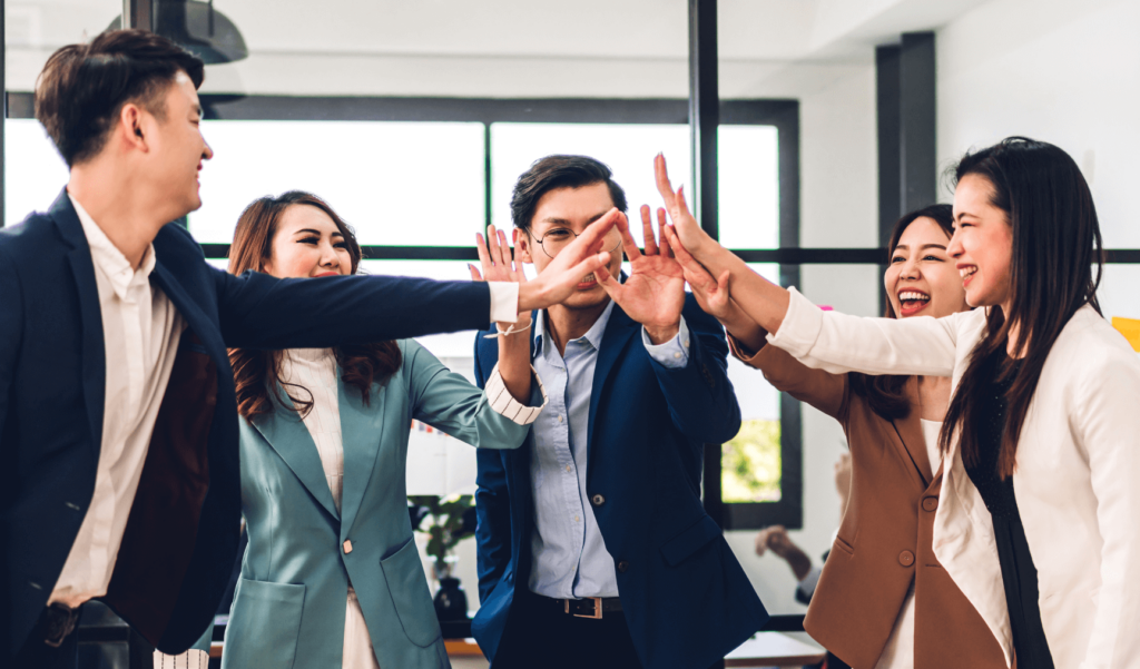 a group of colleagues high fiving each other